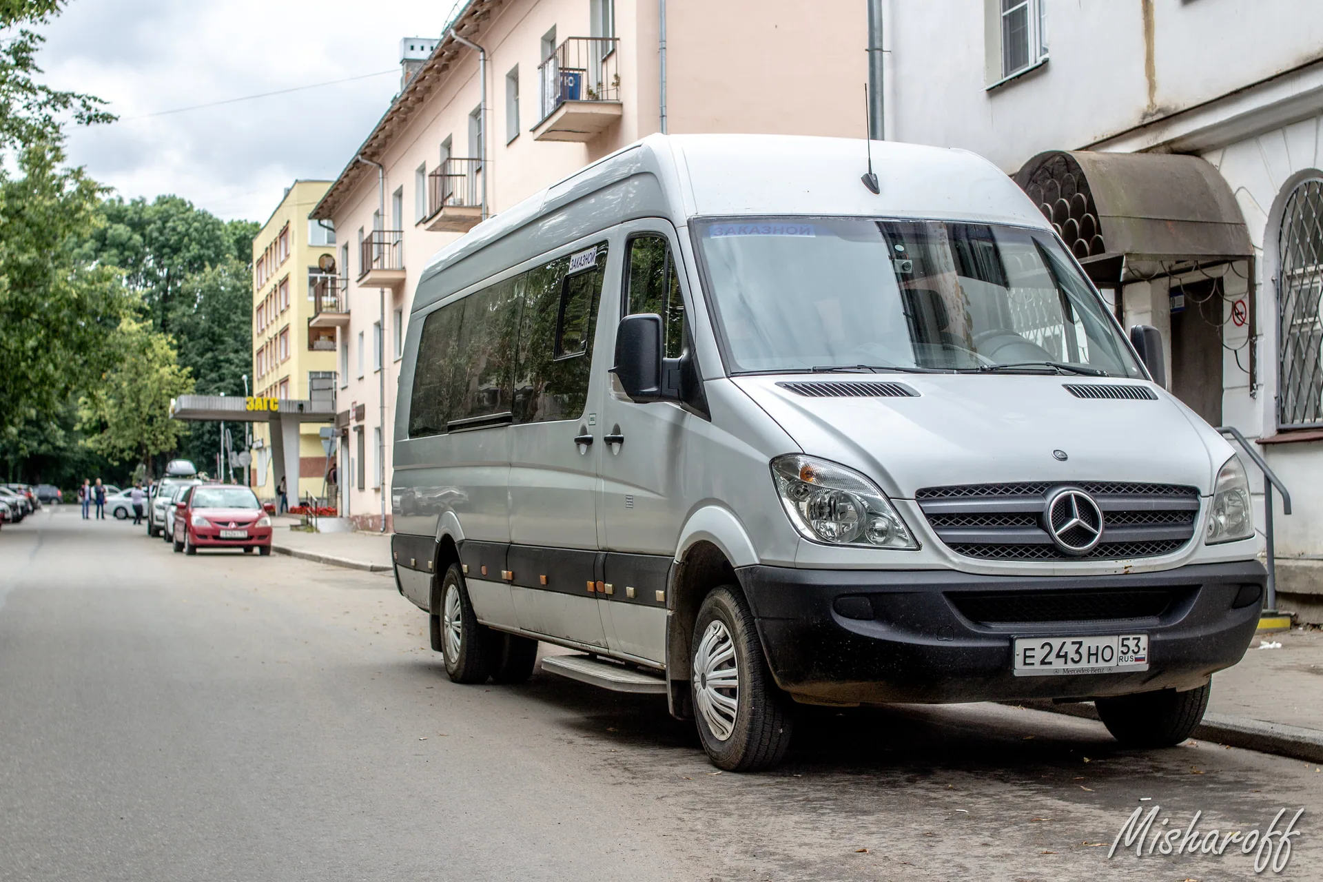 Белый пассажирский микроавтобус Mercedes-Benz Sprinter на городской улице
